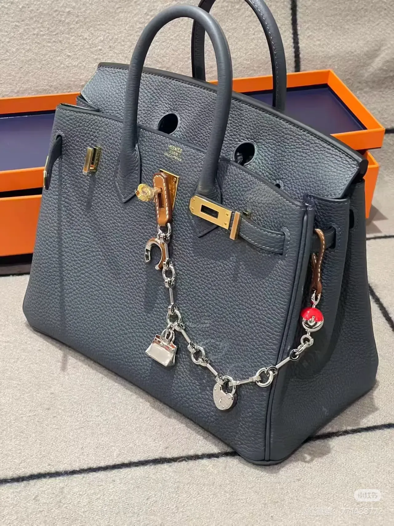 Fauve / Rouge de cœur&nbsp;掛於&nbsp;Birkin 25（深灰）：&nbsp;深灰色袋身配暖色吊飾，色差令包鏈更突出