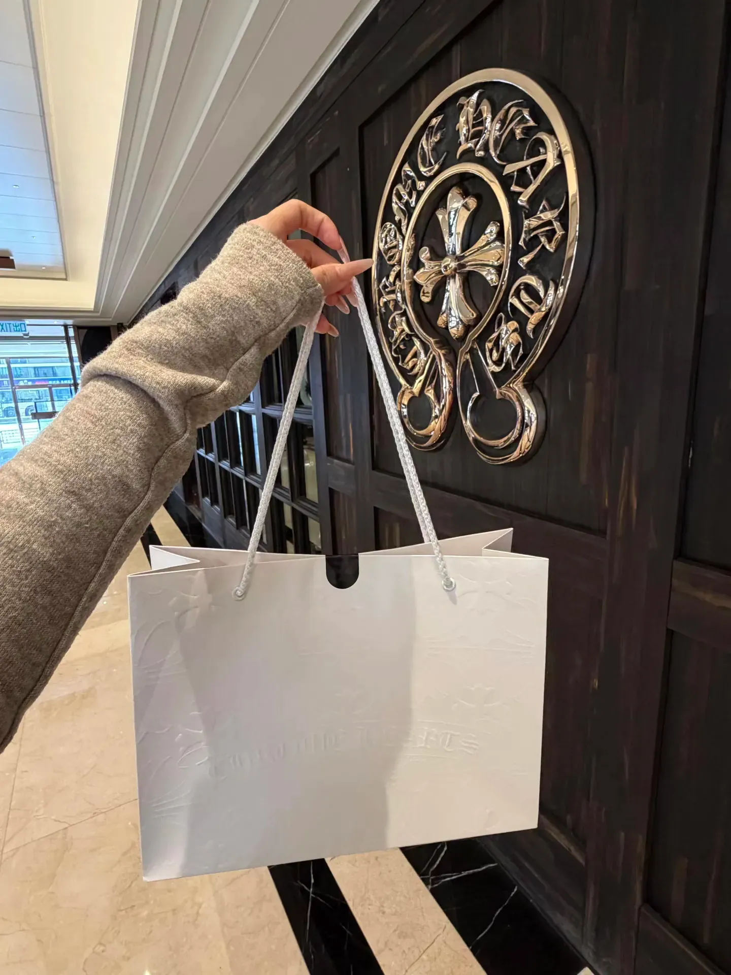 網民於香港&nbsp;Chrome Hearts&nbsp;門市購物後，在店外拍攝的紙袋照片，反映實體購買仍需親身到店進行