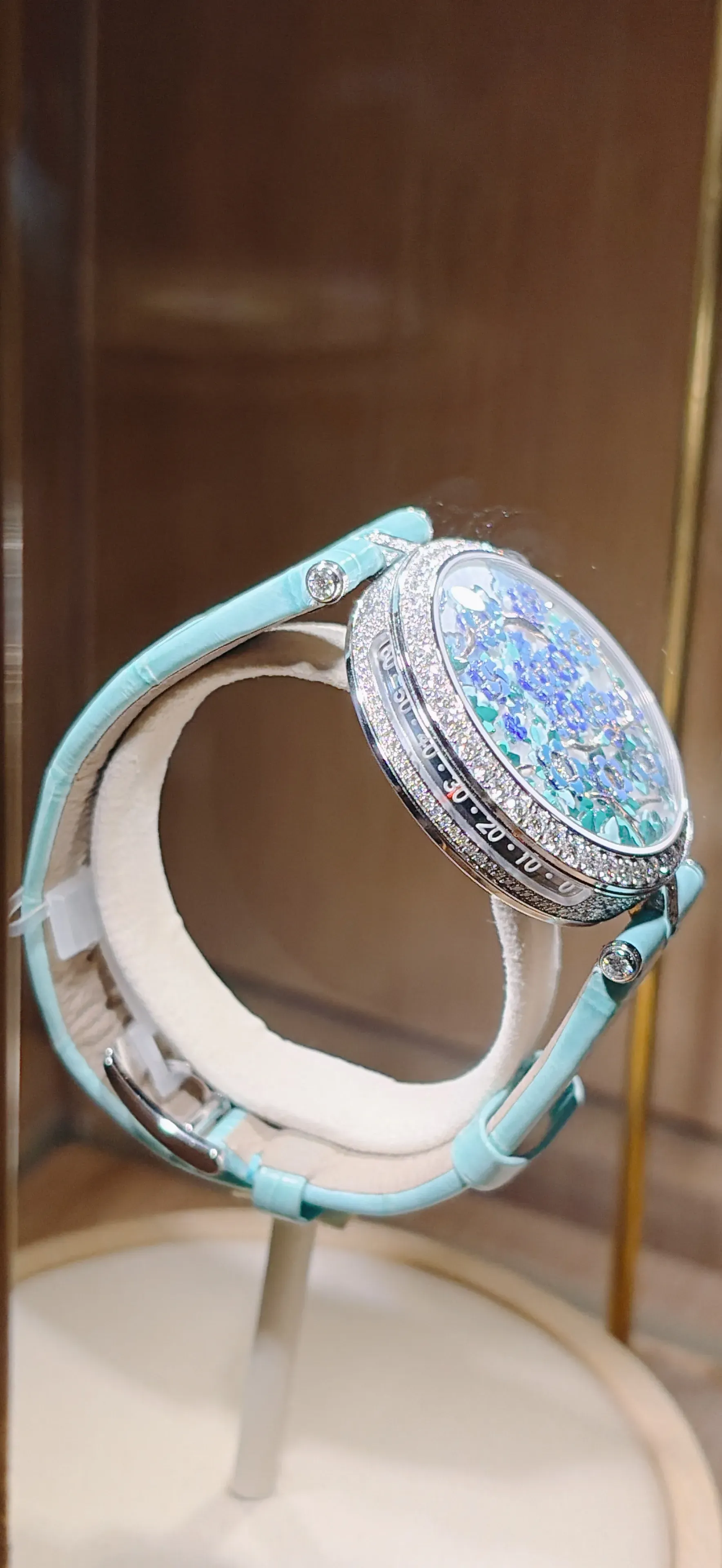 分鐘透過錶殼側邊的線性刻度顯示，以垂直指針沿&nbsp;0–60&nbsp;讀取，避免干擾錶面花朵動態。